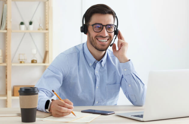 Telefonní operátor v Enkidoo, který v kanceláři u počítače radí zákazníkům, jak změnit dodavatele energií či zajistit přepis energie.